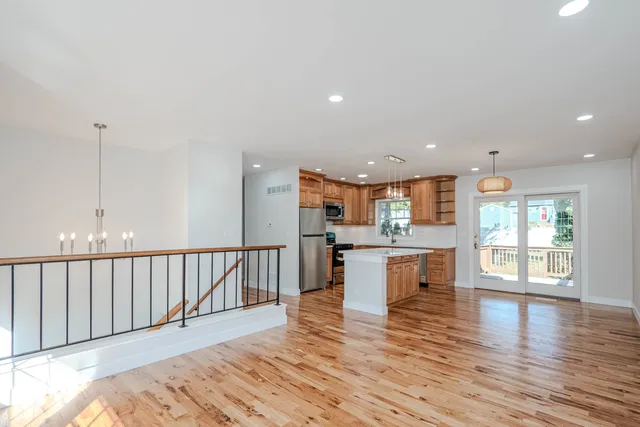 a open kitchen with white cabinets wooden floor and stainless steel appliances