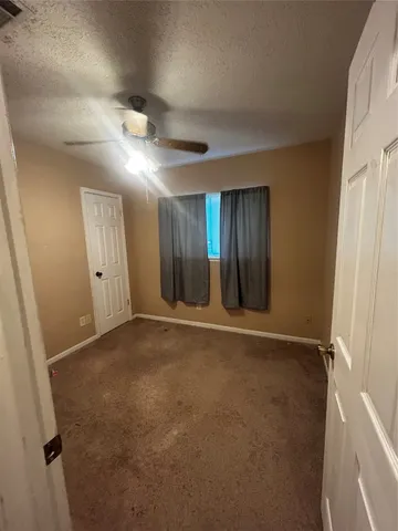 an empty room with windows and closet