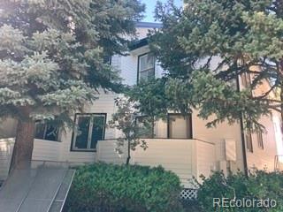 133 South Jackson Street, Unit A6 Denver, CO 80209 - Photo 4 of 19 a view of a white house next to a yard with plants and trees