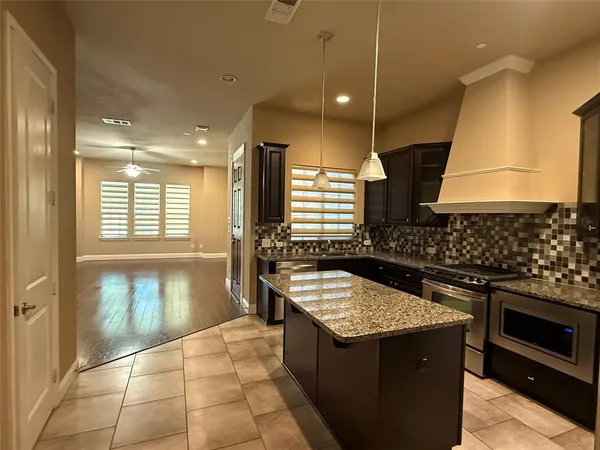 a kitchen with a stove kitchen island granite countertop a sink and a stove