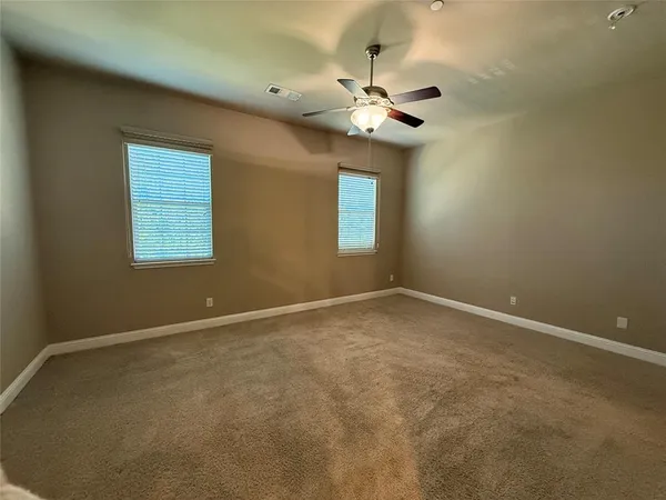 a view of an empty room with a chandelier fan