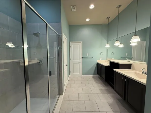 a bathroom with a bathtub a sink a mirror and a glass door shower