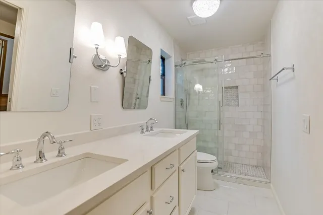 a bathroom with a double vanity sink mirror double and shower