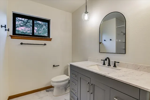 a bathroom with a toilet a sink and mirror