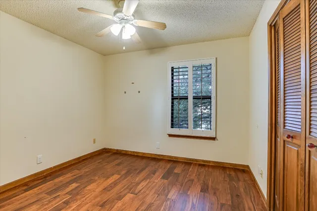 an empty room with a window and wooden floor