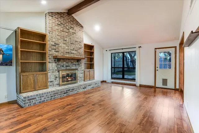 wooden floor fireplace and windows in an empty room