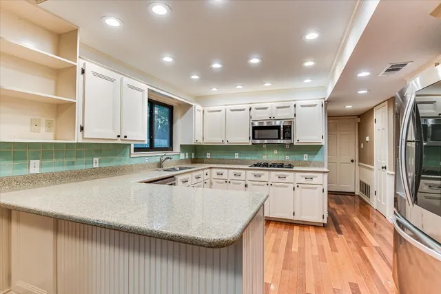 a kitchen with sink refrigerator and microwave