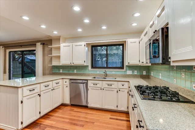 a large kitchen with stainless steel appliances granite countertop a stove and a sink
