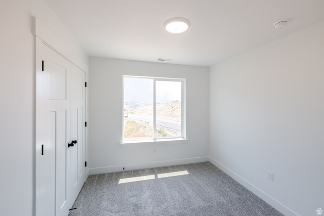 195 West Harmony Rdg Parkway, Unit 601 Mapleton, UT 84664 - Photo 15 of 23 Neutral-toned room featuring a large window, white walls, and gray carpet