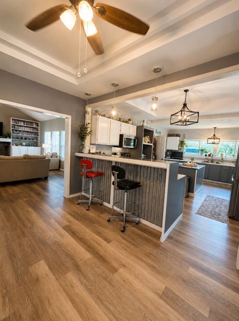 221 Winding Way Road Marble Falls, TX 78654 - Photo 8 of 19 An inviting open-concept layout features rich flooring and a stylish kitchen island with seating.