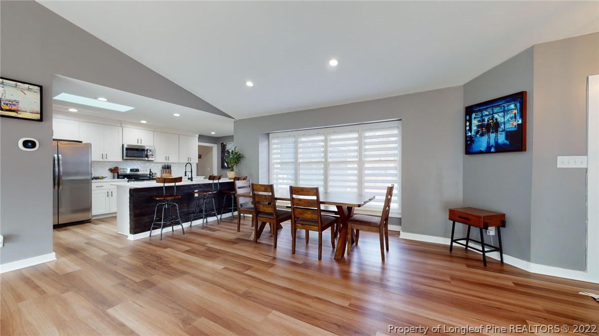 680 Burning Tree Road Pinehurst, NC 28374 - Photo 16 of 43 a living room with furniture wooden floor and kitchen view