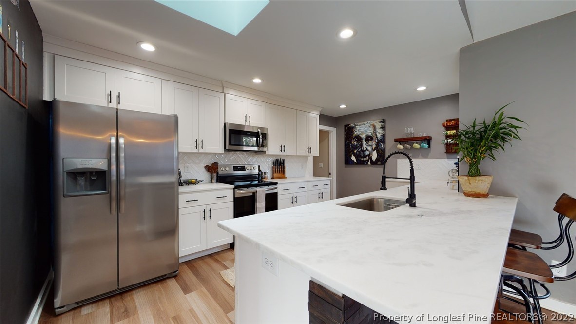 680 Burning Tree Road Pinehurst, NC 28374 - Photo 17 of 43 a kitchen with sink a refrigerator and chairs