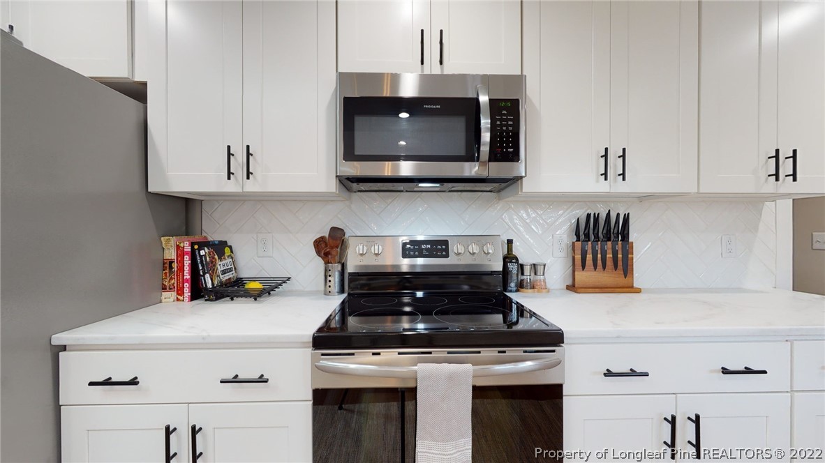 680 Burning Tree Road Pinehurst, NC 28374 - Photo 21 of 43 a kitchen with stainless steel appliances granite countertop a stove and a microwave