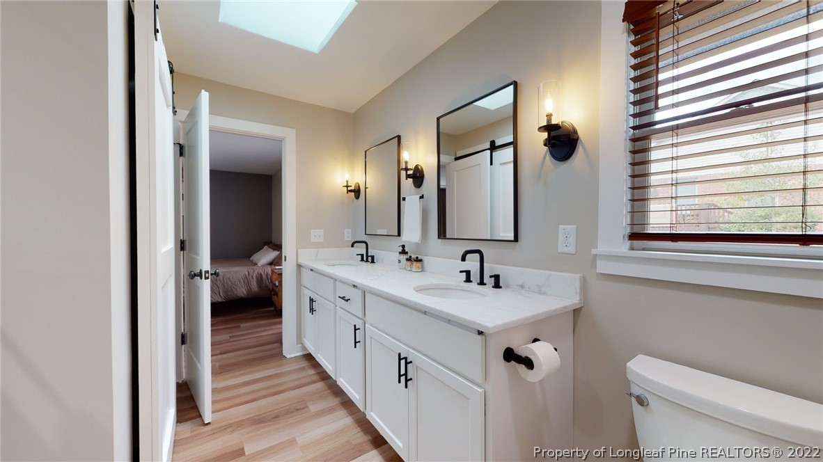 680 Burning Tree Road Pinehurst, NC 28374 - Photo 33 of 43 a en suite bathroom with a double vanity sink and a mirror