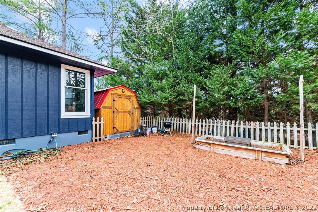 680 Burning Tree Road Pinehurst, NC 28374 - Photo 35 of 43 a view of a backyard with a small cabin and wooden fence