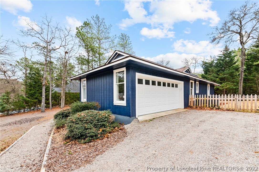 680 Burning Tree Road Pinehurst, NC 28374 - Photo 10 of 43 a view of a house with a wooden fence next to a road