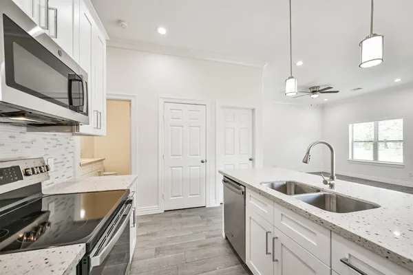 a kitchen with a sink a faucet a chandelier and living room view