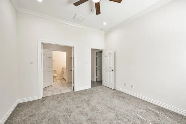 an empty room with a window and a fan