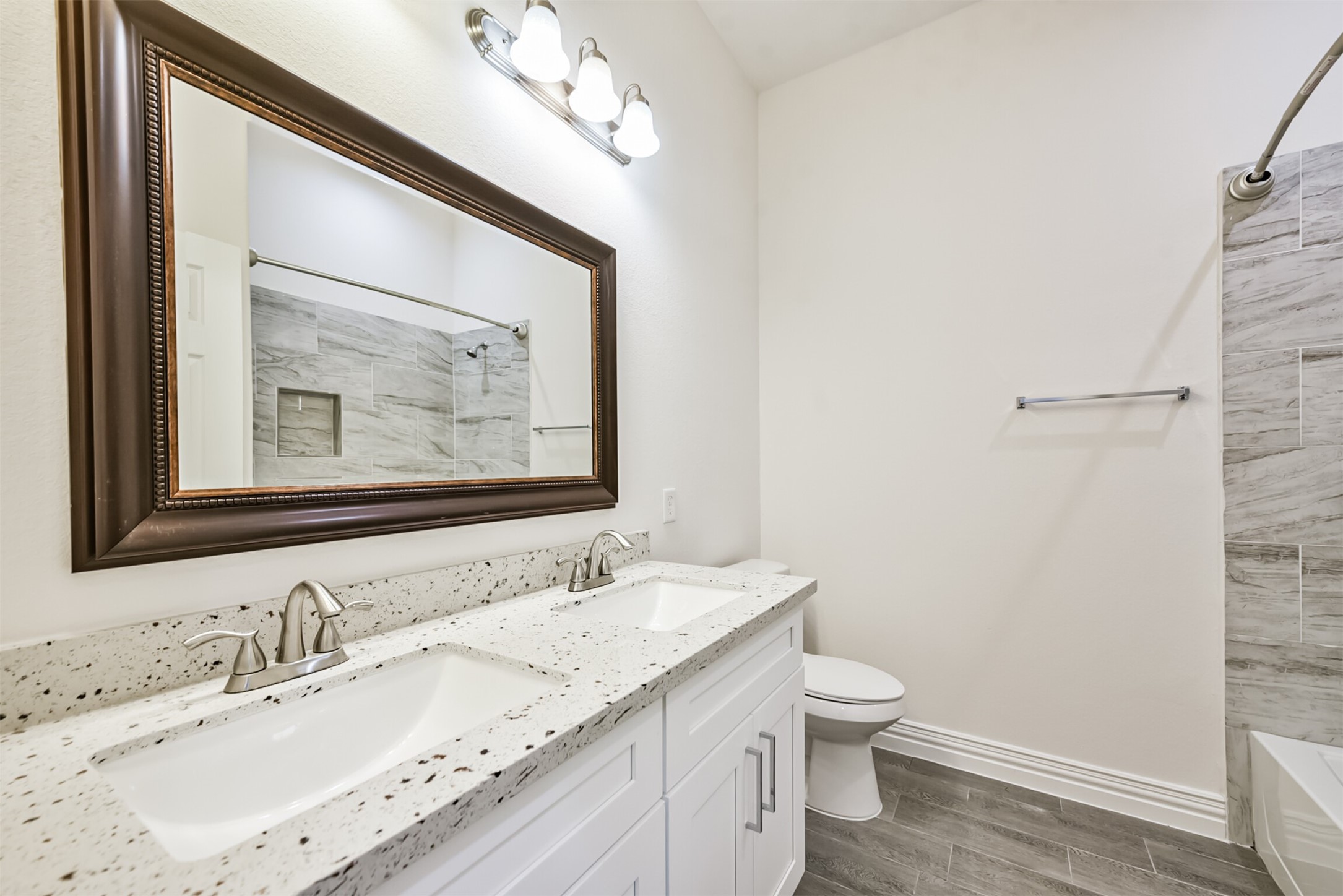 5114 Higgins Street, Unit A Houston, TX 77033 - Photo 23 of 28 a bathroom with a granite countertop sink a toilet and a mirror