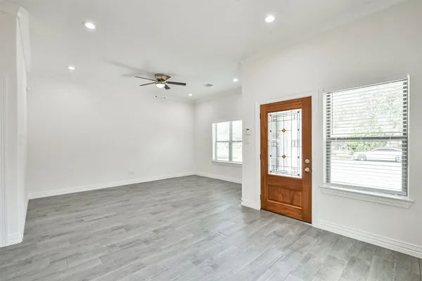 a large white kitchen with a refrigerator a stove top oven a sink and a window