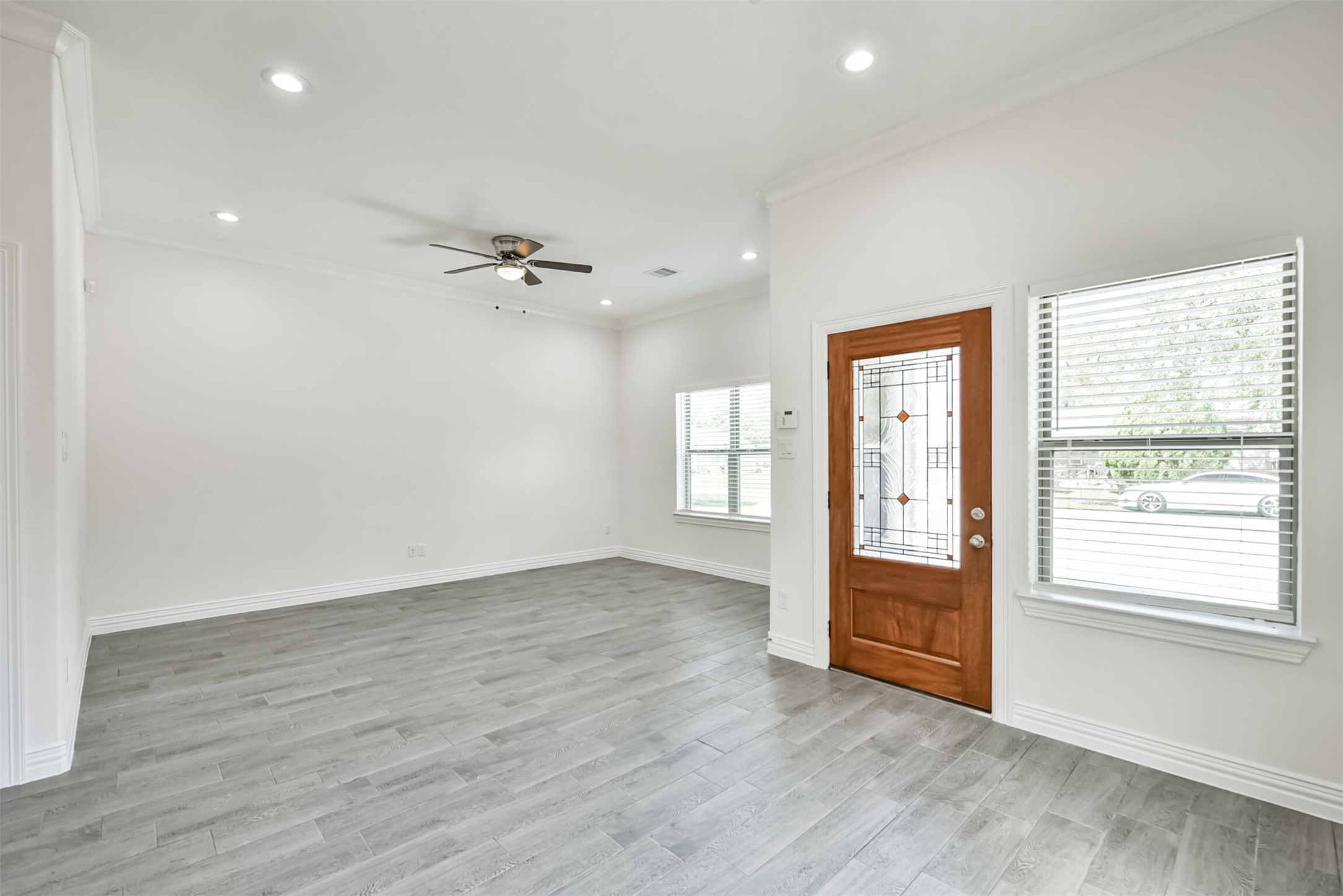 5114 Higgins Street, Unit A Houston, TX 77033 - Photo 5 of 28 an empty room with wooden floor a ceiling fan and windows