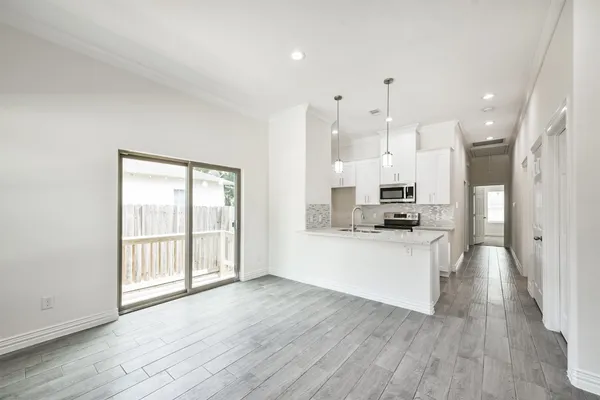 a view of a kitchen with a sink and wooden cabinet
