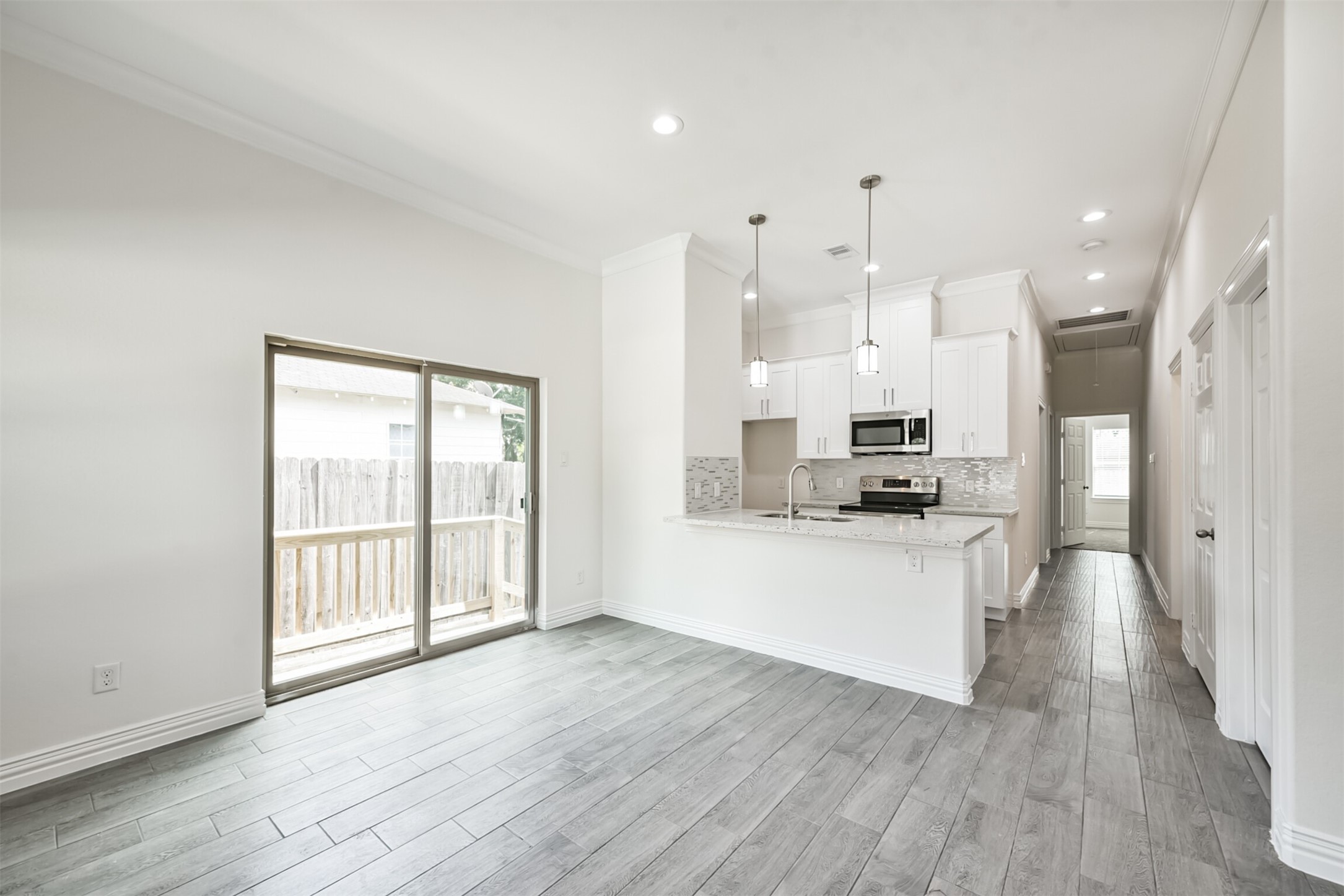 5114 Higgins Street, Unit A Houston, TX 77033 - Photo 8 of 28 a large kitchen with white cabinets and wooden floor