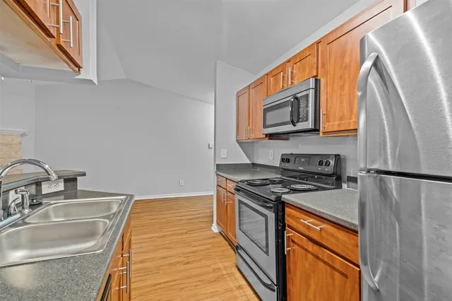 a kitchen with stainless steel appliances granite countertop a sink and a stove