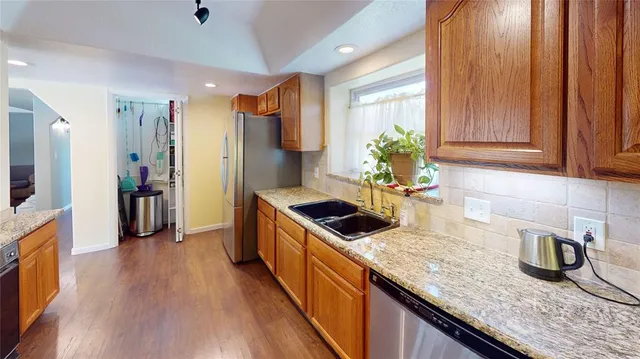 a kitchen with granite countertop a sink a counter space and cabinets
