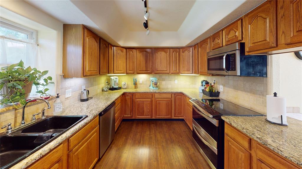 202 River Oaks Road Early, TX 76802 - Photo 12 of 37 a kitchen with granite countertop a sink a counter space appliances and cabinets
