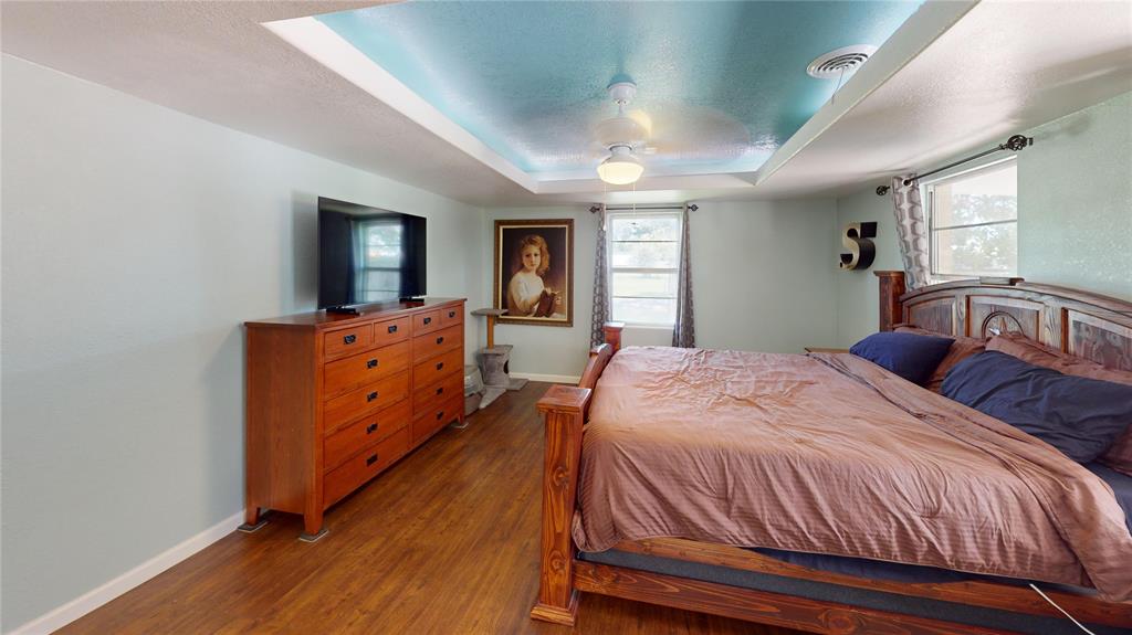 202 River Oaks Road Early, TX 76802 - Photo 18 of 37 a bedroom with a bed and a dresser with mirror