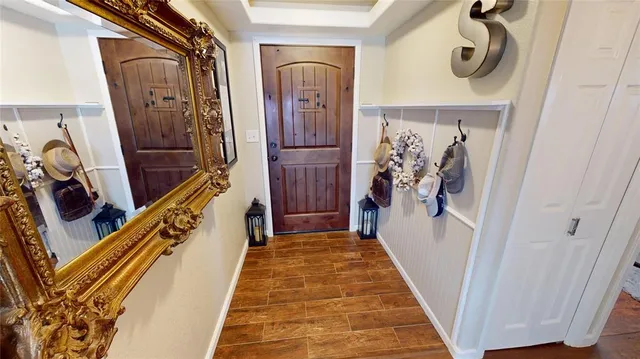 a view of a hallway with wooden floor and stairs