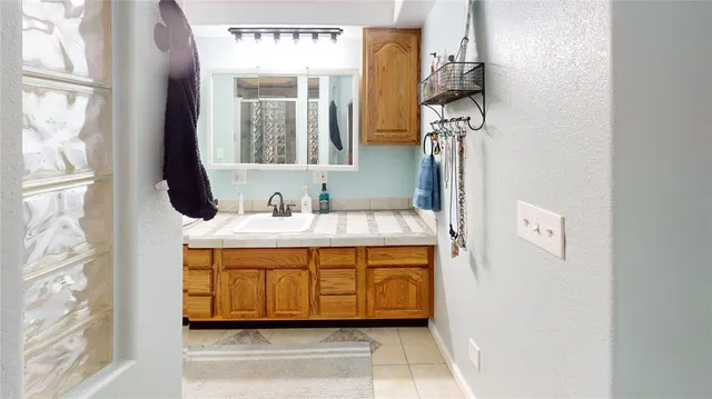 a bathroom with a sink a mirror and next to a window