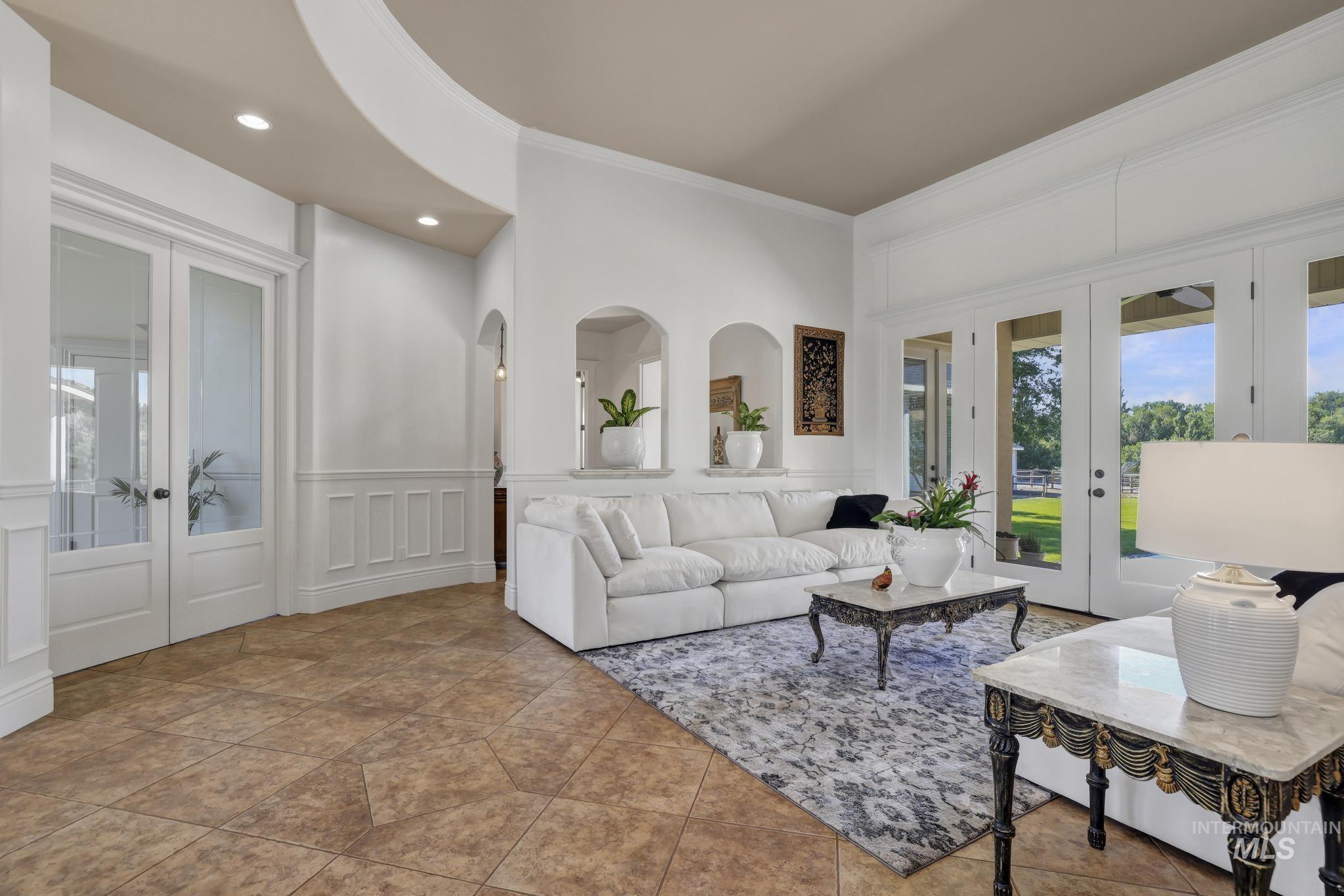 1301 Kanaka Rapids Road Buhl, ID 83316 - Photo 11 of 50 Spacious living area featuring expansive glass-paneled doors, arched wall niches, a curved entryway, recessed lighting, and tile flooring