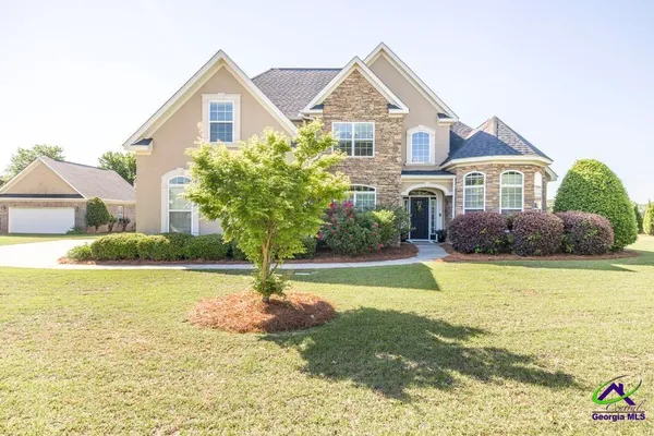 a front view of a house with yard and swimming pool
