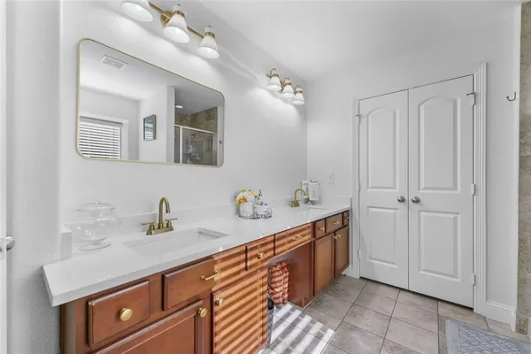 a spacious bathroom with a double vanity sink a mirror and a bathtub