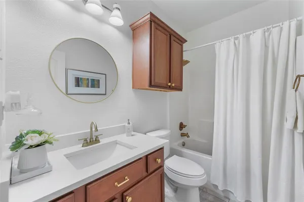 a bathroom with a granite countertop sink and a toilet