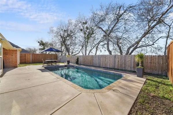 a backyard of a house with table and chairs