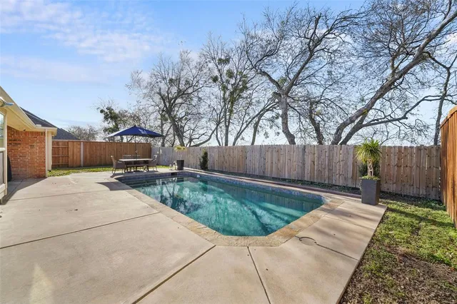 a backyard of a house with table and chairs