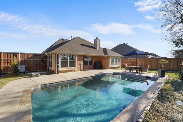 a front view of a house with swimming pool having outdoor seating