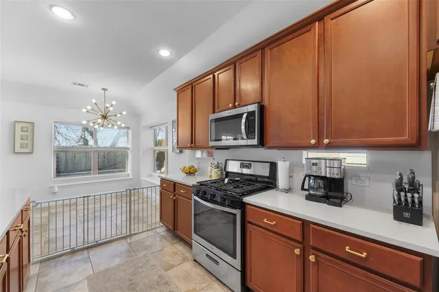 a kitchen with stainless steel appliances granite countertop a stove a sink and a microwave