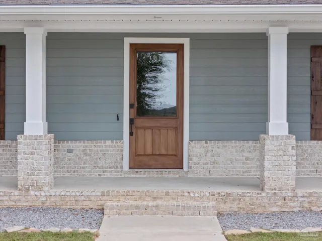 a view of a livingroom with a flat screen tv wooden floor and a ceiling fan