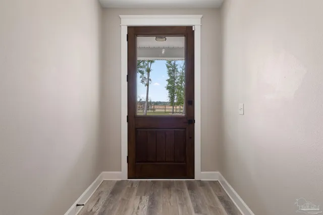 a view of a livingroom with a flat screen tv wooden floor and a ceiling fan
