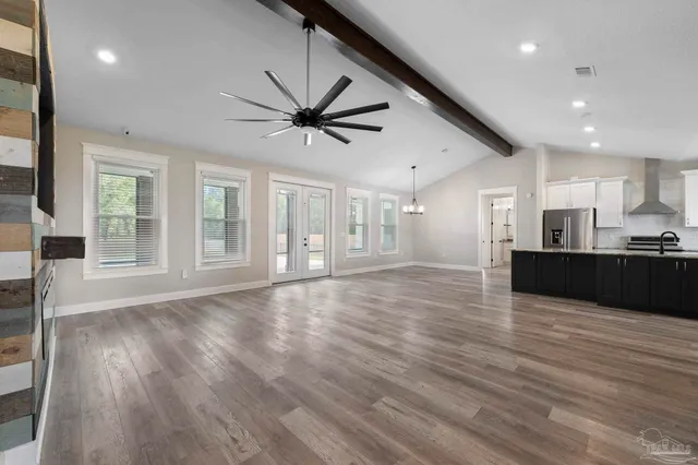 a view of a livingroom with wooden floor and a flat screen tv