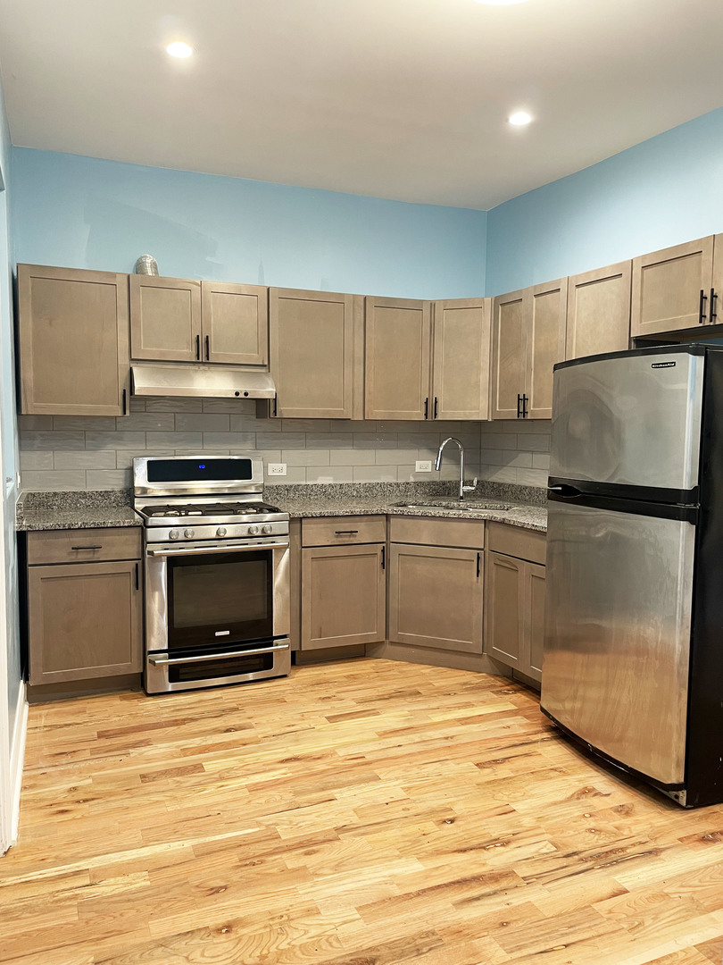 523 West 65th Place Chicago, IL 60621 - Photo 14 of 19 a kitchen with stainless steel appliances granite countertop a stove top oven and cabinets