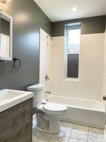 an empty room with wooden floor and fan