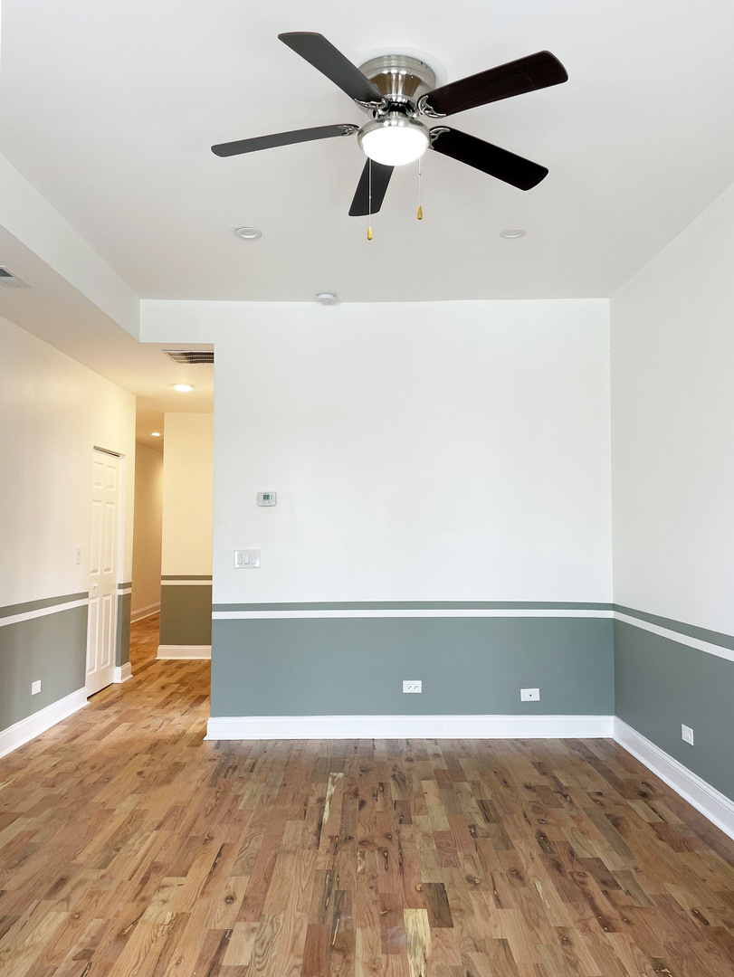 523 West 65th Place Chicago, IL 60621 - Photo 16 of 19 an empty room with wooden floor and fan