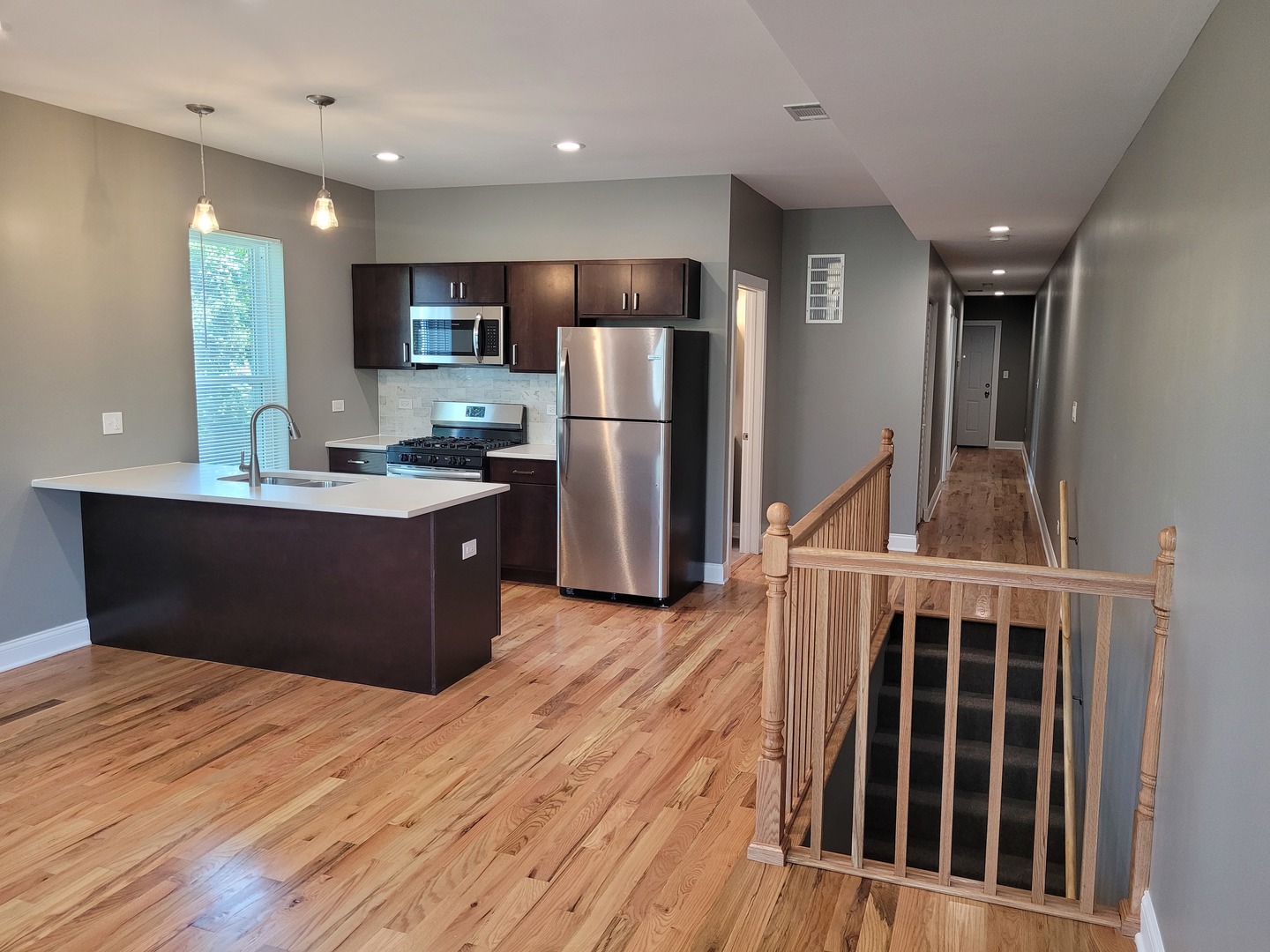 523 West 65th Place Chicago, IL 60621 - Photo 2 of 19 a kitchen with stainless steel appliances kitchen island granite countertop a refrigerator oven a sink with wooden cabinets and wooden floor