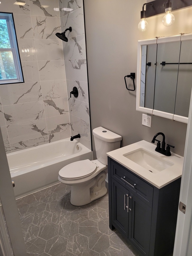 523 West 65th Place Chicago, IL 60621 - Photo 5 of 19 a bathroom with a double vanity sink toilet and shower