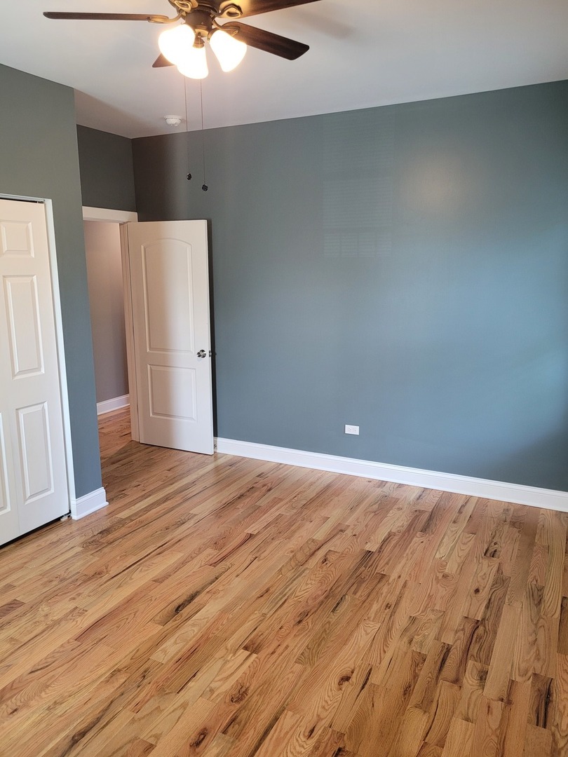 523 West 65th Place Chicago, IL 60621 - Photo 7 of 19 an empty room with wooden floor and entryway